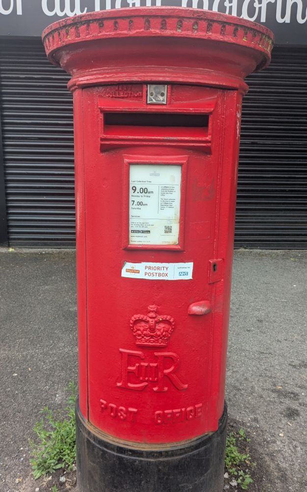 Red Post box from the time of Queen Elizabeth 2nd, circular round top and cylinder long middle, black bottom. Crown and the Letters (E II R) the II smaller in size then the initials