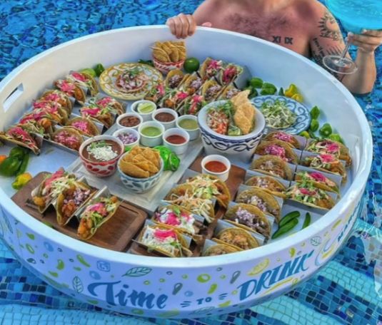 photo of a pool floating food tray with tacos in it.