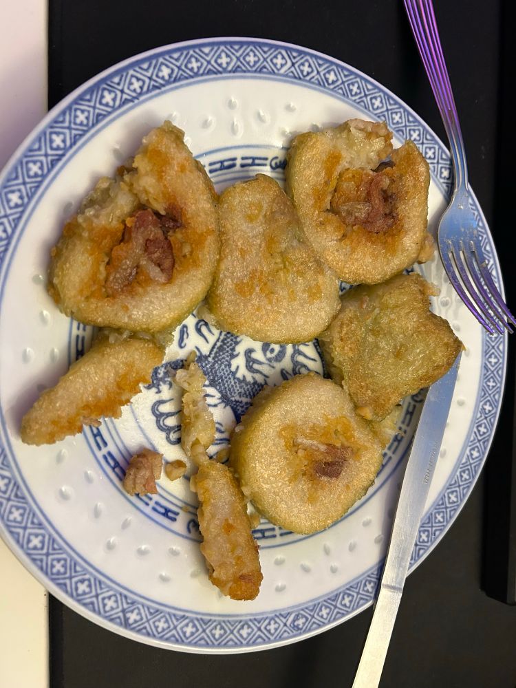 Tranches de Banh têt cuites à la poêle dans une assiette blanche avec motifs bleus asiatiques