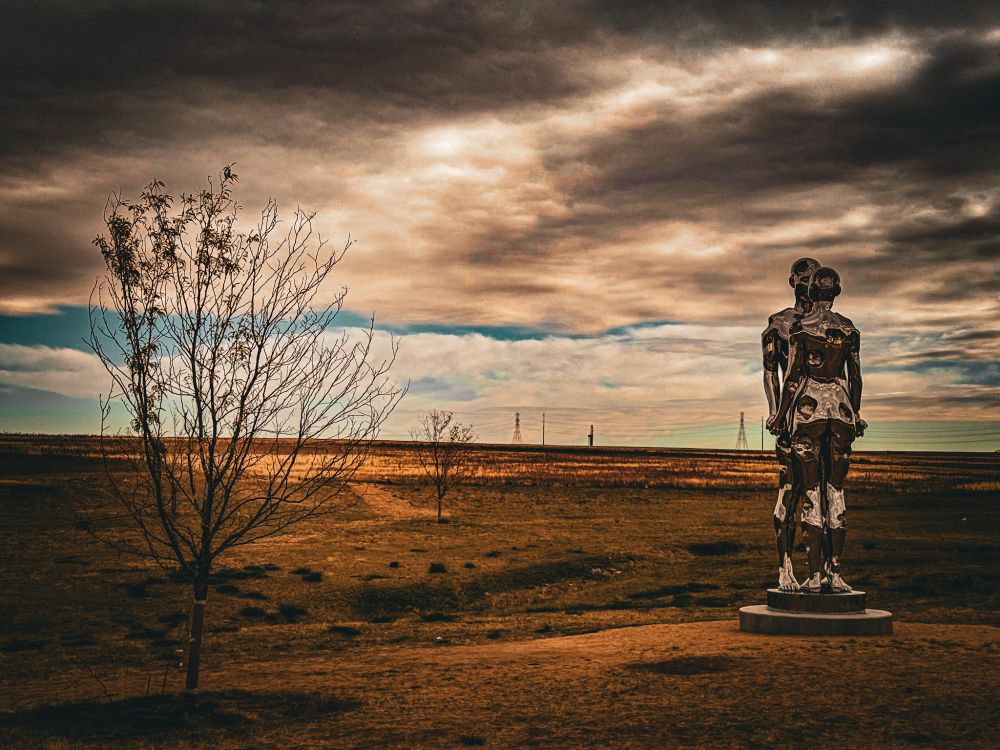 “Broken but Together” is a 25-foot-tall sculpture made of mirrored polished steel. It depicts two figures in an embrace. The sculpture is located in the Aurora Highlands in Aurora, CO. Photo by the Adventure Hermit.