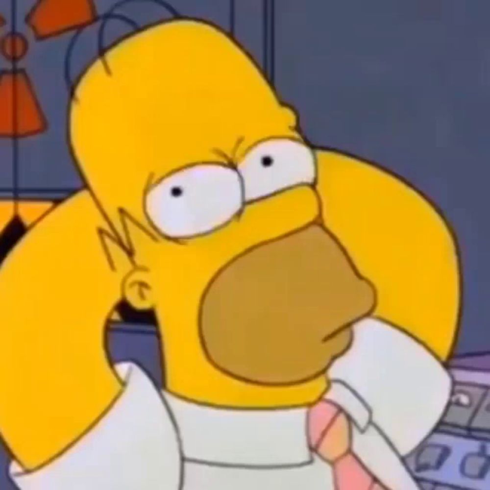 homer simpson from the simpsons is wearing a white shirt and tie and making a funny face .