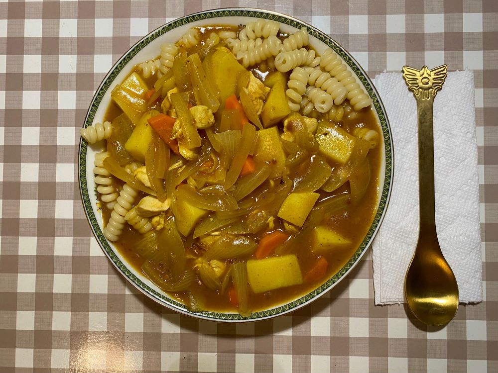 a bowl of curry over pasta