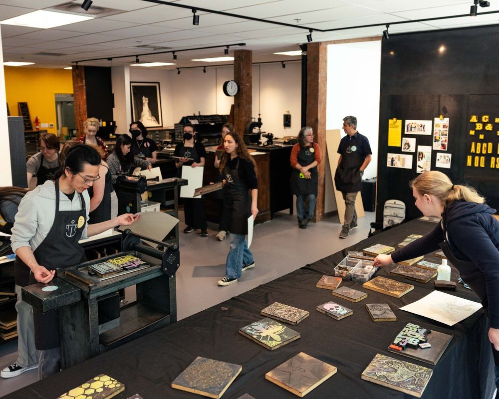 Students from the University of Washington Textual Studies 402: Book Arts course work on printing their own letterpress pages.