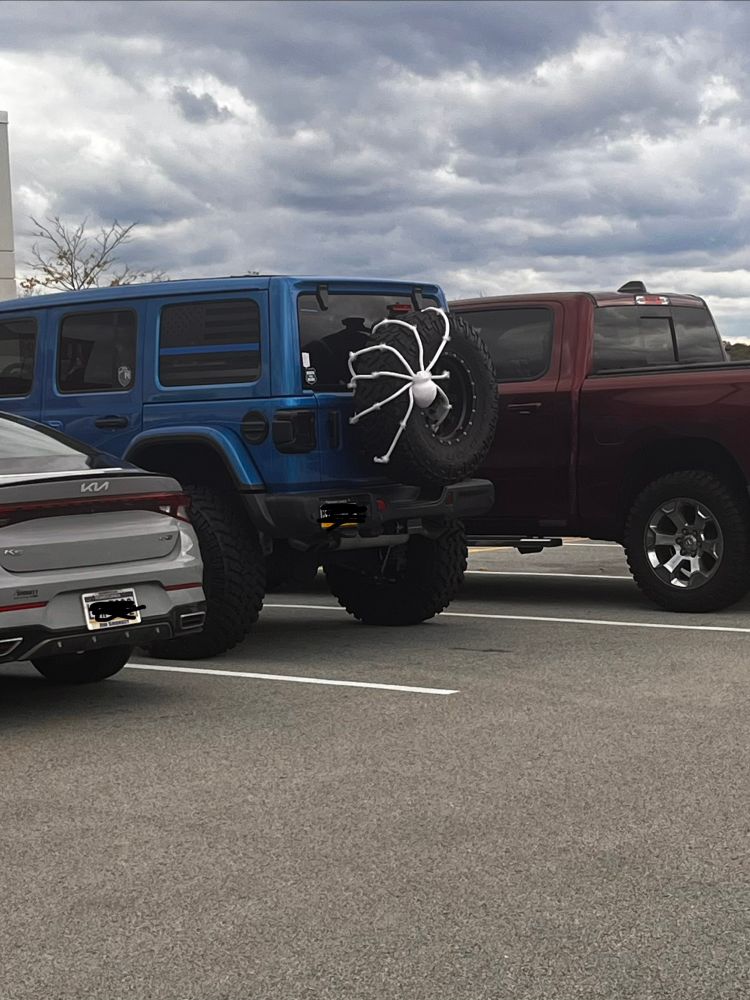 A jeep with a giant skeleton spider on the spare wheel 