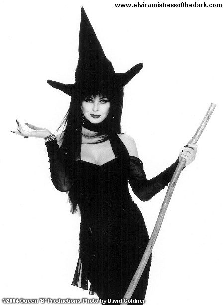 B/W photo of Elvira Mistress of the Dark in a witch hat and holding a broom