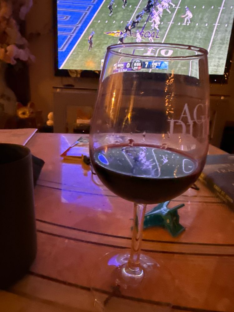 my red wine glass, with Lions vs Vikings game in the background.