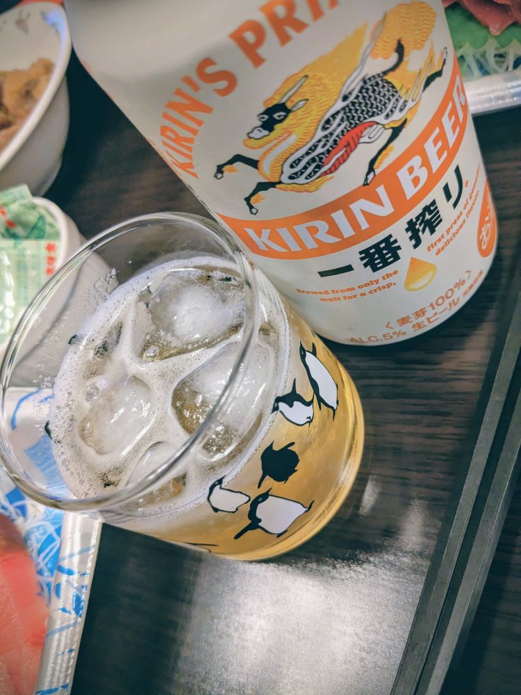 一番搾りのビール缶。ペンギングラスに梅酒、氷。