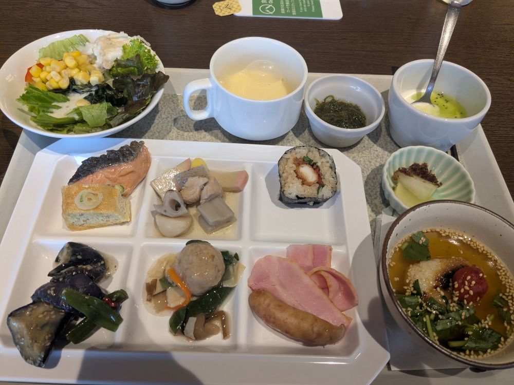 野菜サラダ、コーンスープ、ヨーグルト、もずく、鮭の焼き漬け、巻き寿司、ナスの煮物、のっぺ、栃尾の油揚げ、出汁茶漬けなどなど