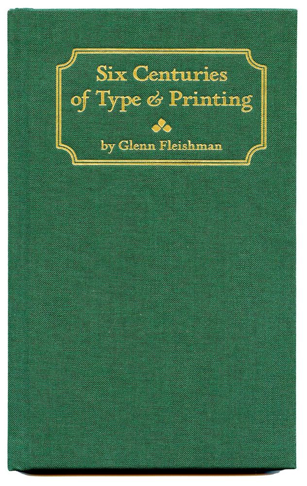Picture of green cloth cover of book, 5 by 8 inches, with foil stamping with an inverted rounded corner rectangle cartouch of two concentric rectangles, with the text Six Centuries of Type & Printing by Glenn Fleishman with a decorative ornament dividing the title and author name