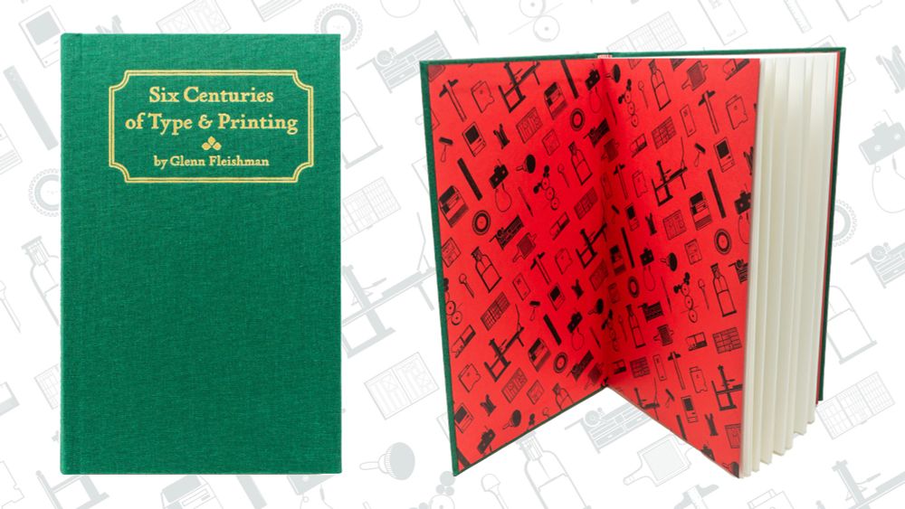 Six Centuries of Type & Printing book (green cloth cover, foil stamping at top in bronze showing title and author) at left; book standing open with black-printed icons on red endpapers at right