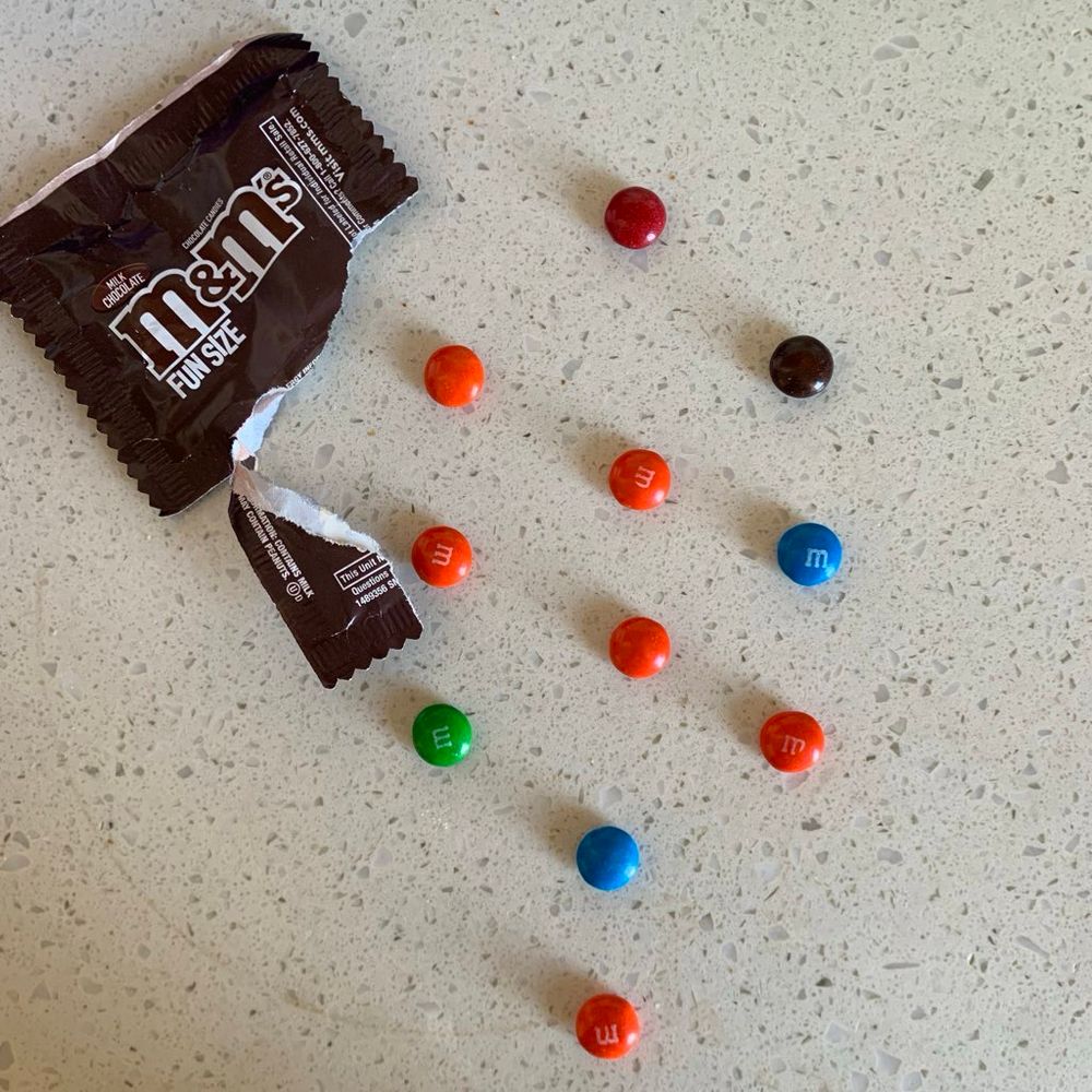 An open snack sized bag of M&Ms, the candies have been placed in the formation of the sefirot (kind of a diamond like shape)