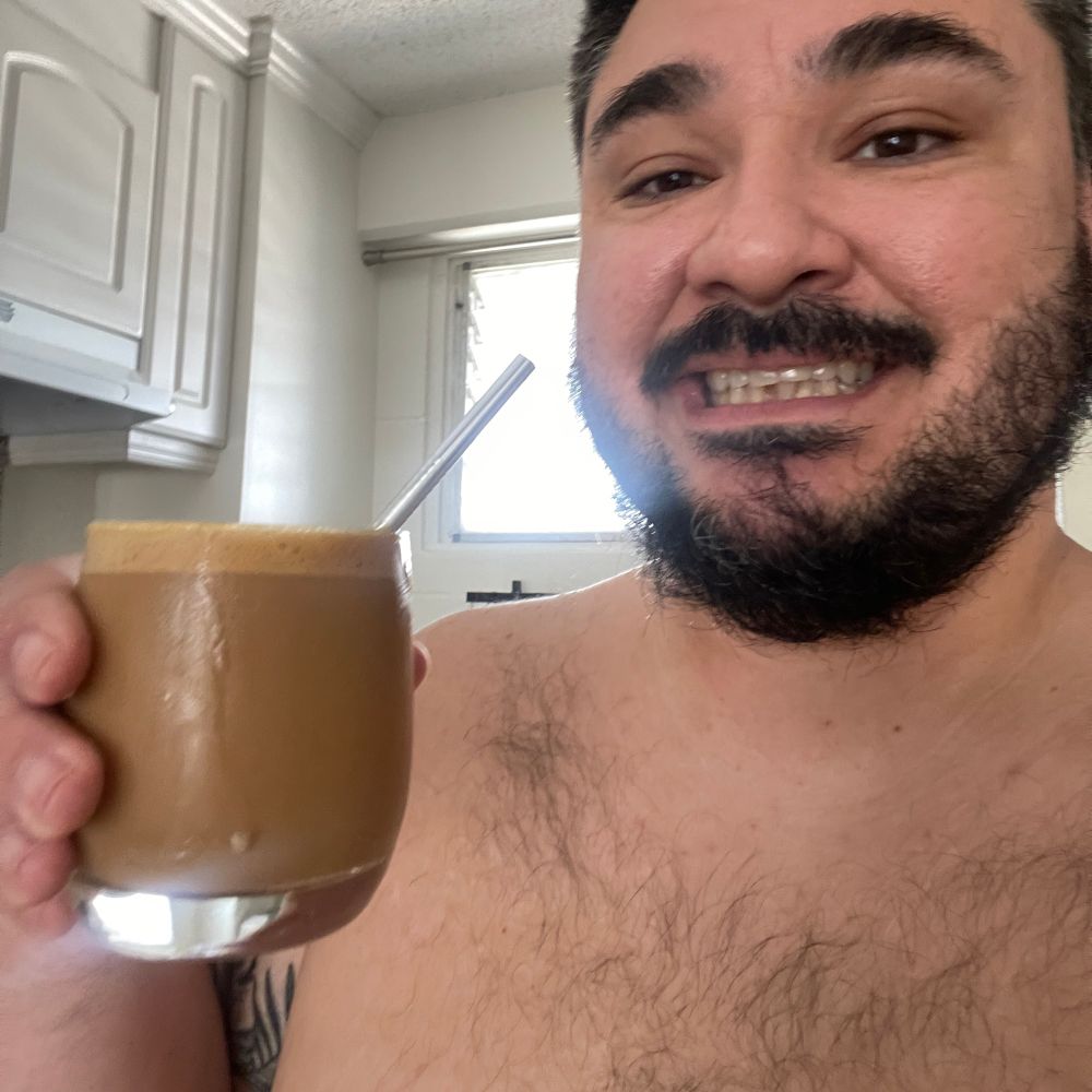gay man holding an iced latte