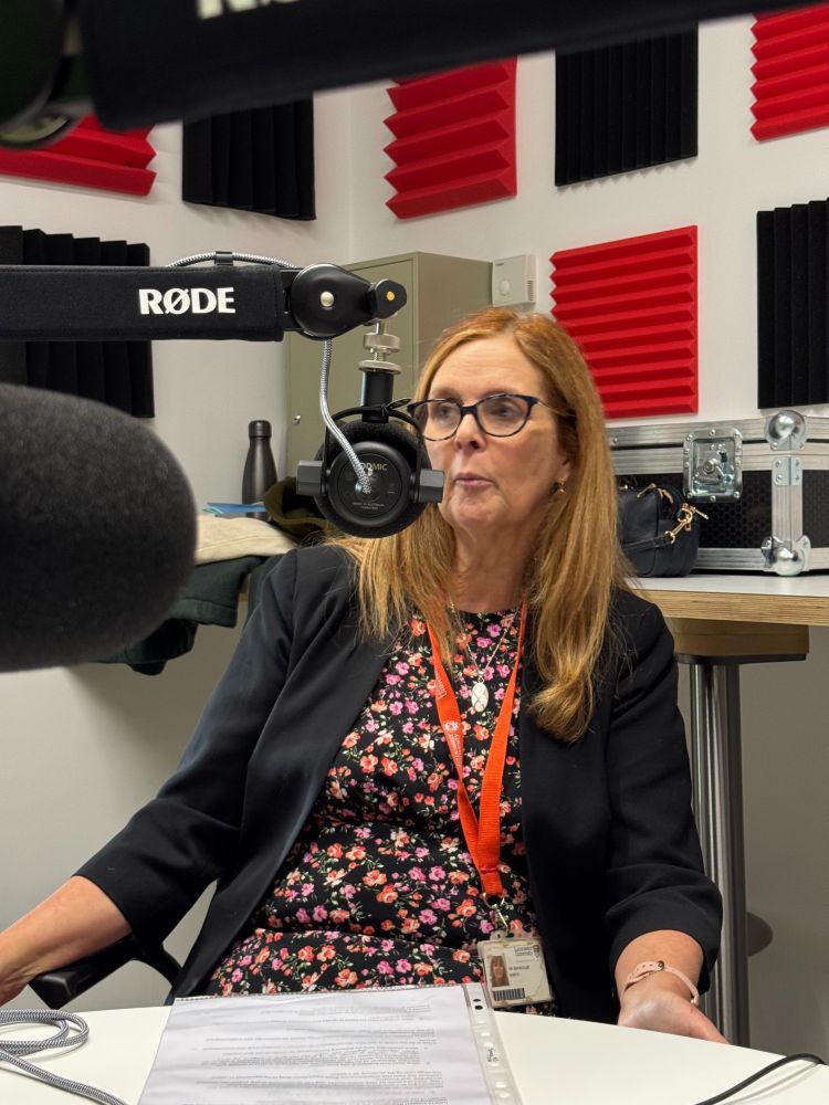Hilary Barraclough talks into the microphone during a podcast recording.