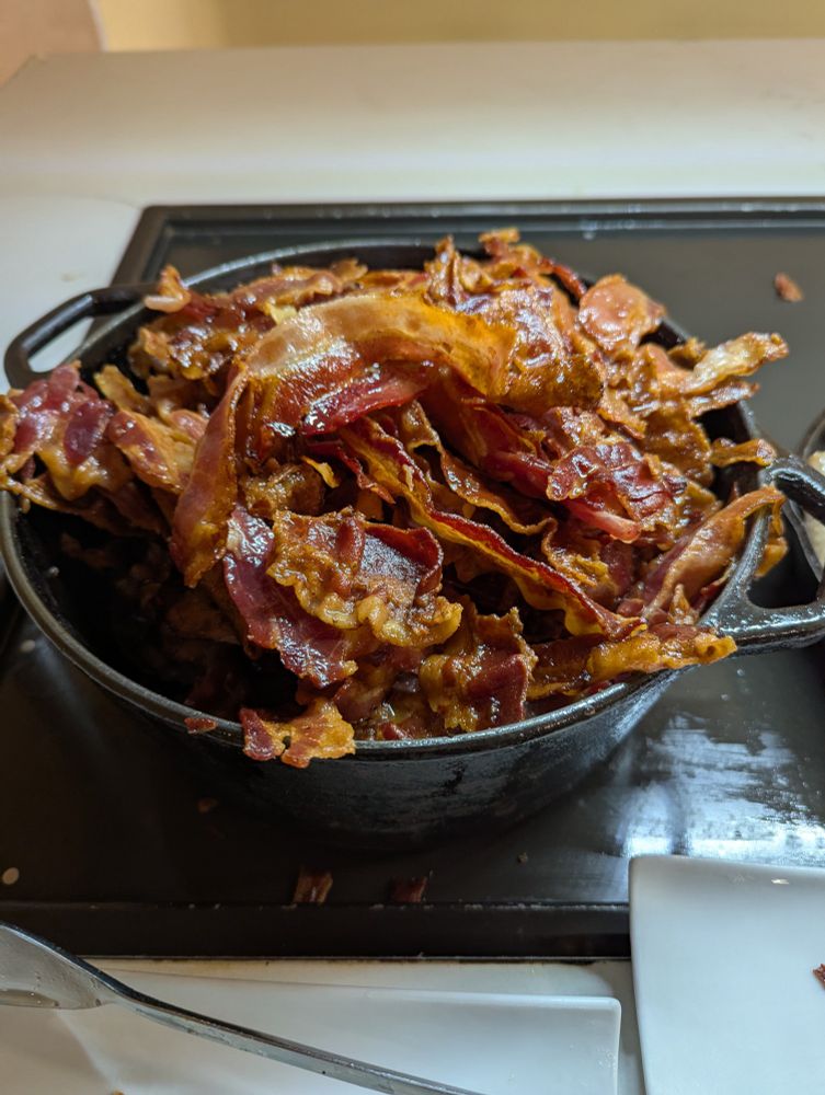 A large cast iron Dutch oven filled with bacon