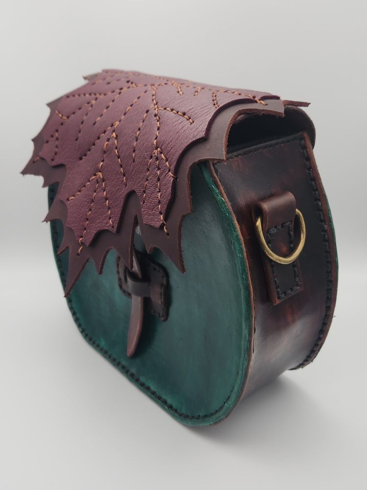3/4 view of a green and brown leather handbag