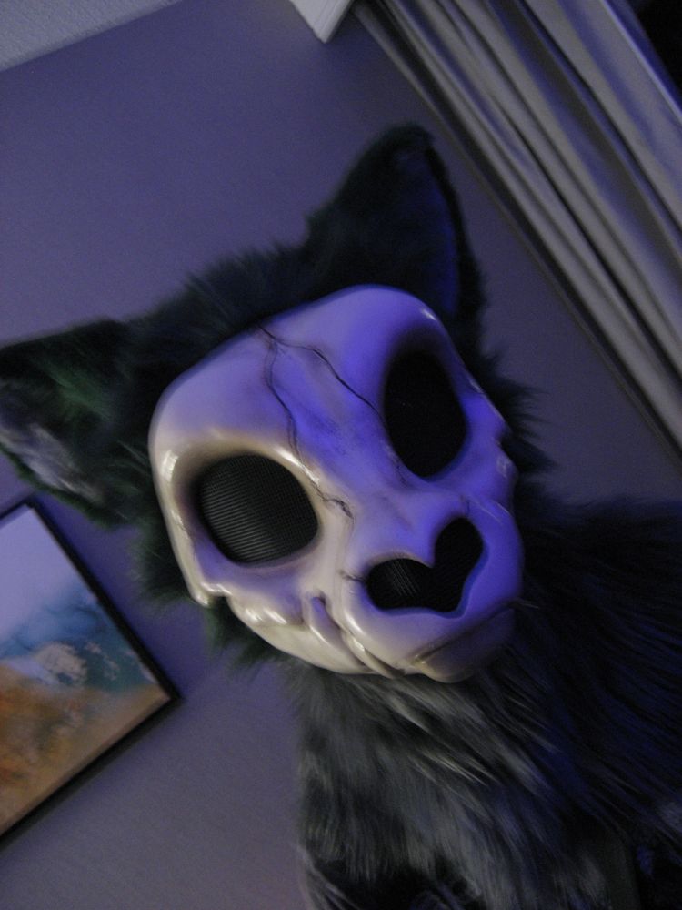 another photo of the same suit in the same setting but this time with a longer shutter speed and no flash, resulting in a bit of motion blur; the scene is lit by a blue light from the ride side and a white light from the left