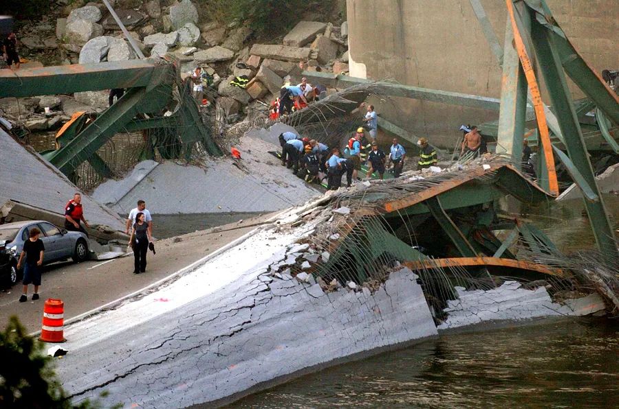 First responders work to rescue people on a collapsed bridge deck. 