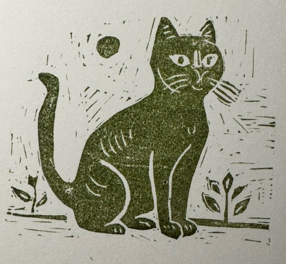 Block print of a kitty, smiling, sitting down. 
