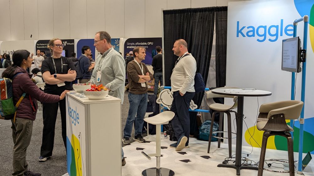 In depth conversations taking place in front of the Kaggle booth.