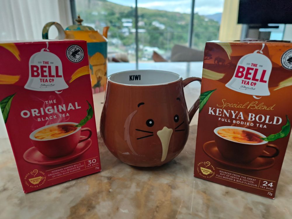 A box of Bell Kenya Bold tea, a box of Bell Original Black tea, and a cute Bell mug that looks like a kiwi.