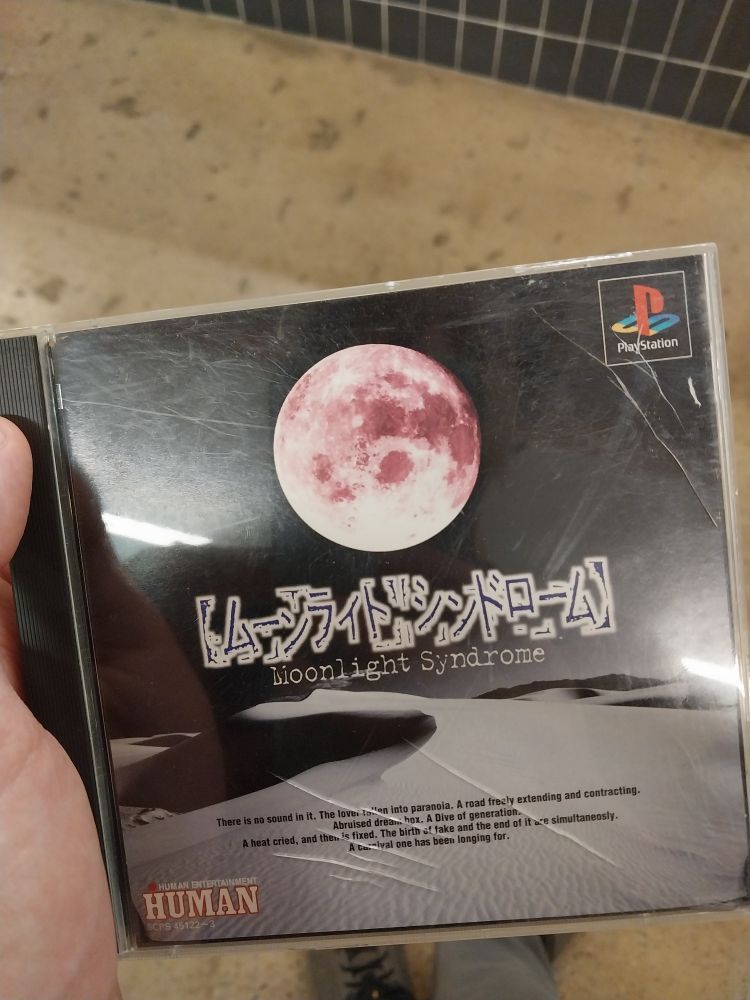 my hand holding copy of Moonlight Syndrome for the playstation 1 in a cracked cd case