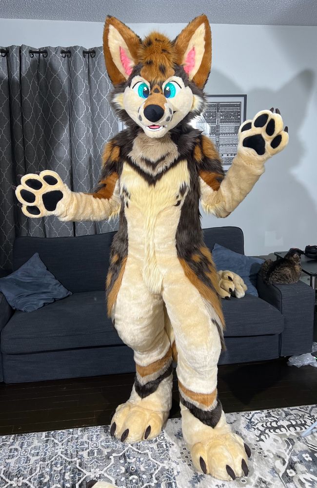 A fursuiter poses for the camera in a “ta-da, it’s me” kind of way