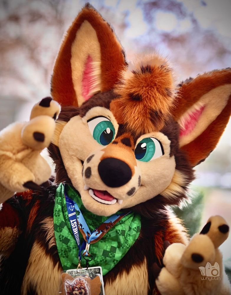a fursuiter points at the camera 
