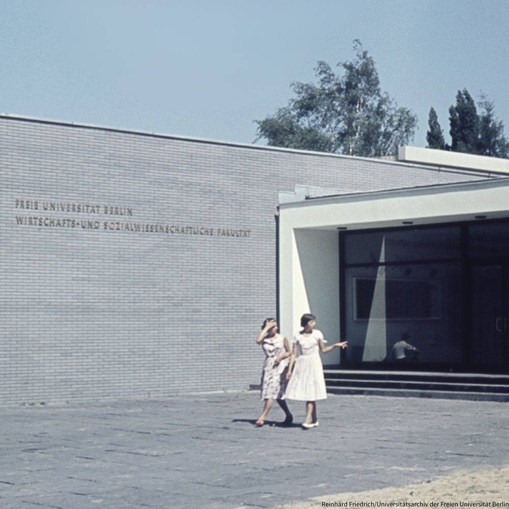 Archivaufnahme aus den 1950er Jahren: Zwei Studentinnen auf dem Campus der Freien Universität vor der Fakultät für Wirtschafts- und Sozialwissenschaften. 