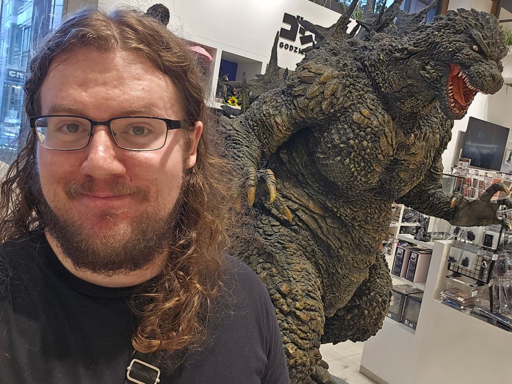 A selfie of me in front the Godzilla Minus One statue in the Godzilla Tokyo store.