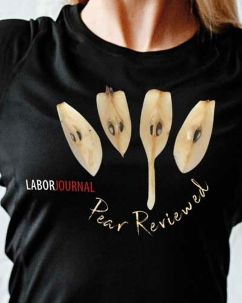 Schwarzes T-Shirt mit Aufdruck von vier Birnenvierteln – die linken drei haben je zwei Kernen, das rechte nur noch einen. Darunter Schriftzug „Pear Reviewed“. Links davon in weiß-rot das Laborjournal-Logo.