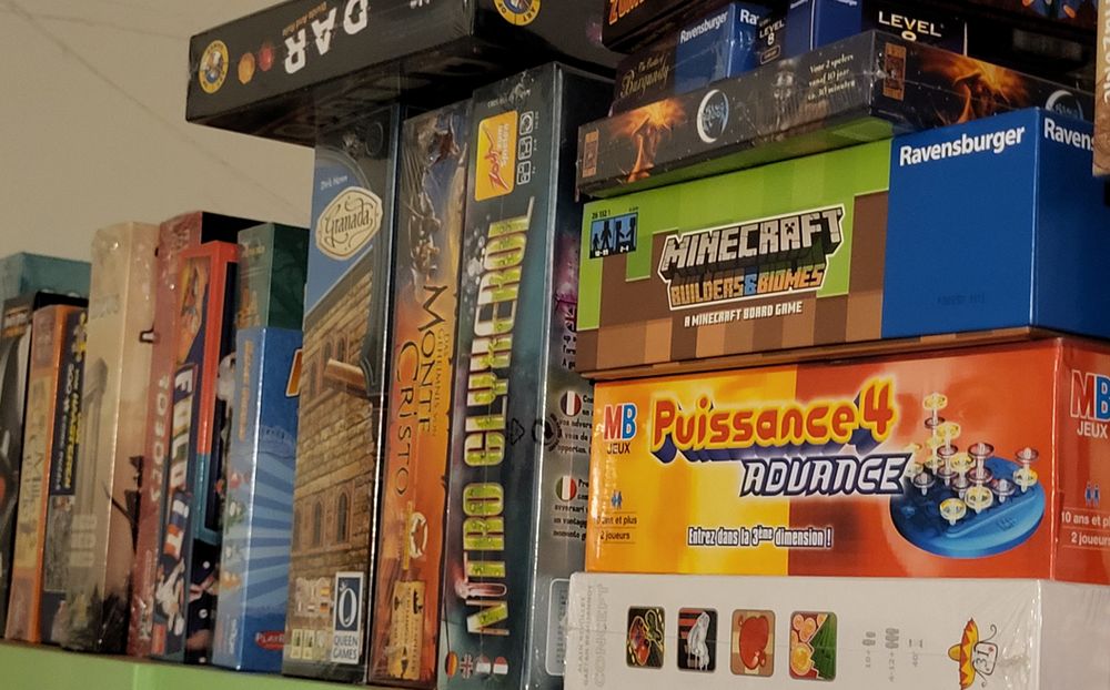 Une quinzaine de boites de jeux de société encore sous cellophane 
