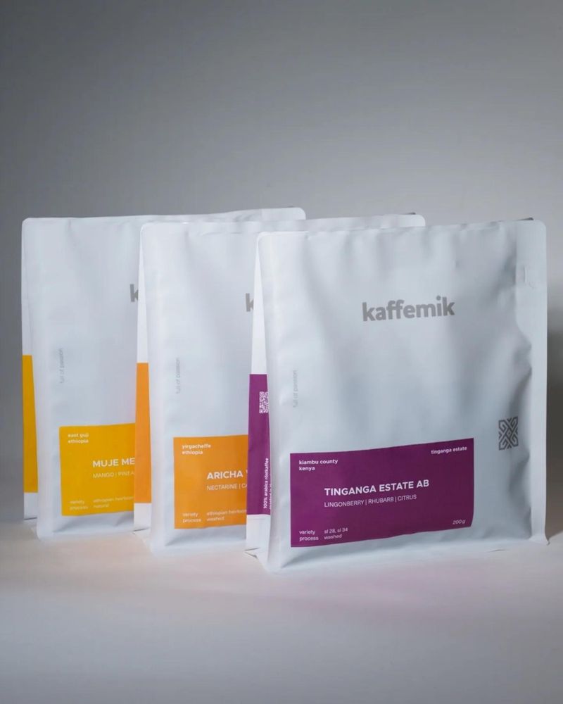 Three bags of kaffemik coffee in a new packaging: white bags with bright yellow, orangen and violett labels