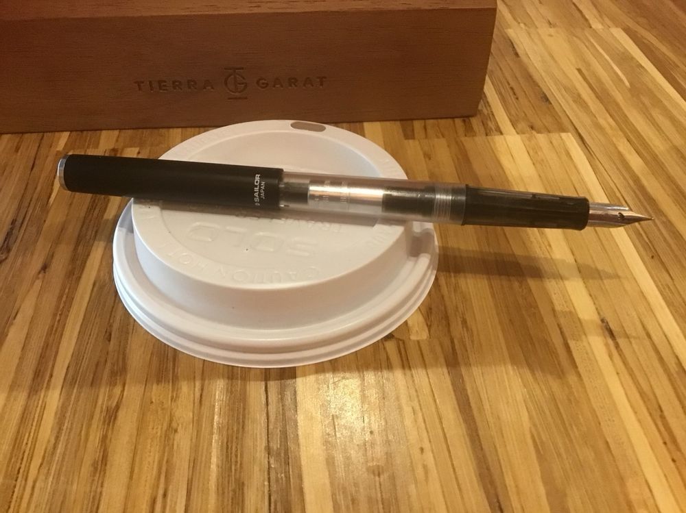The same pen, uncapped with a steel fine nib and black plastic section.