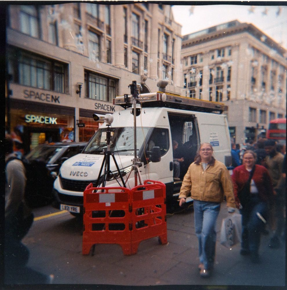 6x6 holga photo of police facial recognition system van operating on regent street, london. pedestrians and cars go past. space.nk shop across the road