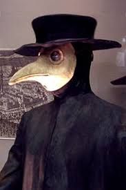 A photo of someone wearing a 17th century plague doctor costume with a flat black hat with a broad brim and a white beaked mask.