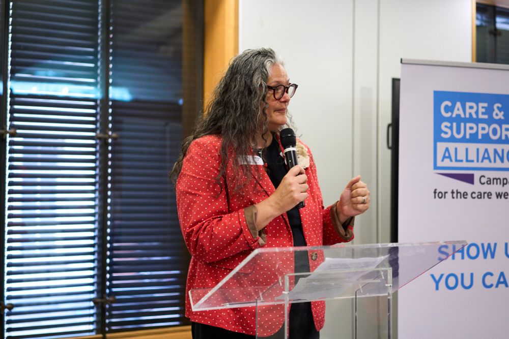 Photo of Emily, CSA Co-Chair, speaking into a microphone.
