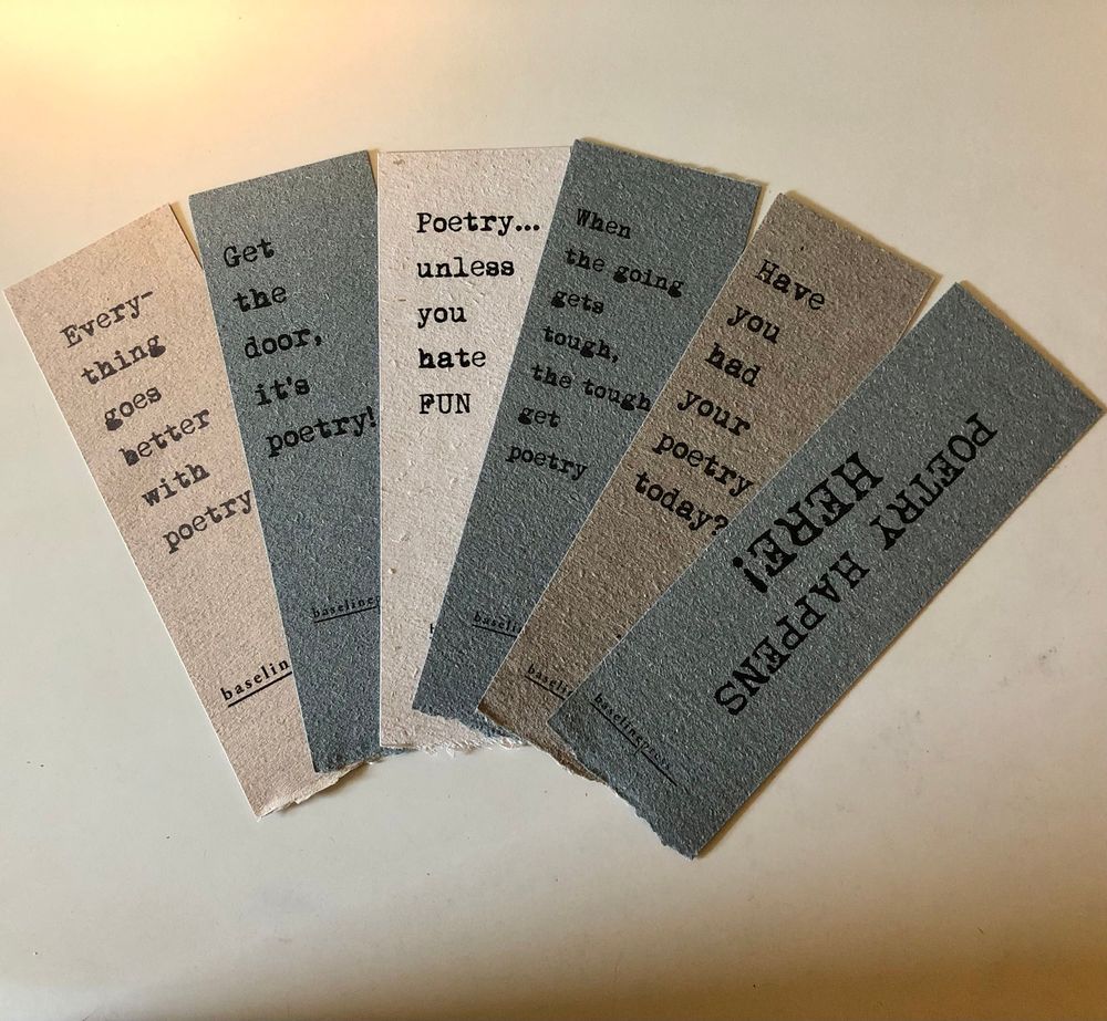 Six Baseline press bookmarks in shades of tan and gray fanned out on a white surface. They read “Everything goes better with poetry,” “Get the door, it’s poetry,” Poetry…unless you hate fun,” When the going gets though, the tough get poetry,” “Have you had your poetry today,” and “Poetry happens here!”