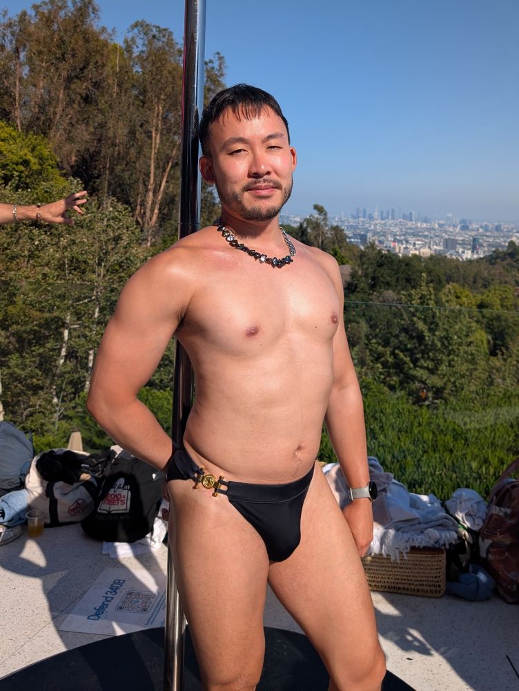 Man in a swimsuit against a pole