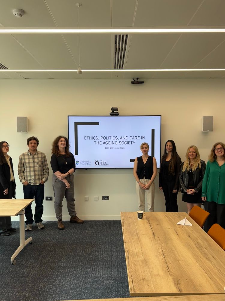 7 academics standing in front of a screen with text that reads: “Ethics, Politics, and Care in the Ageing Society”