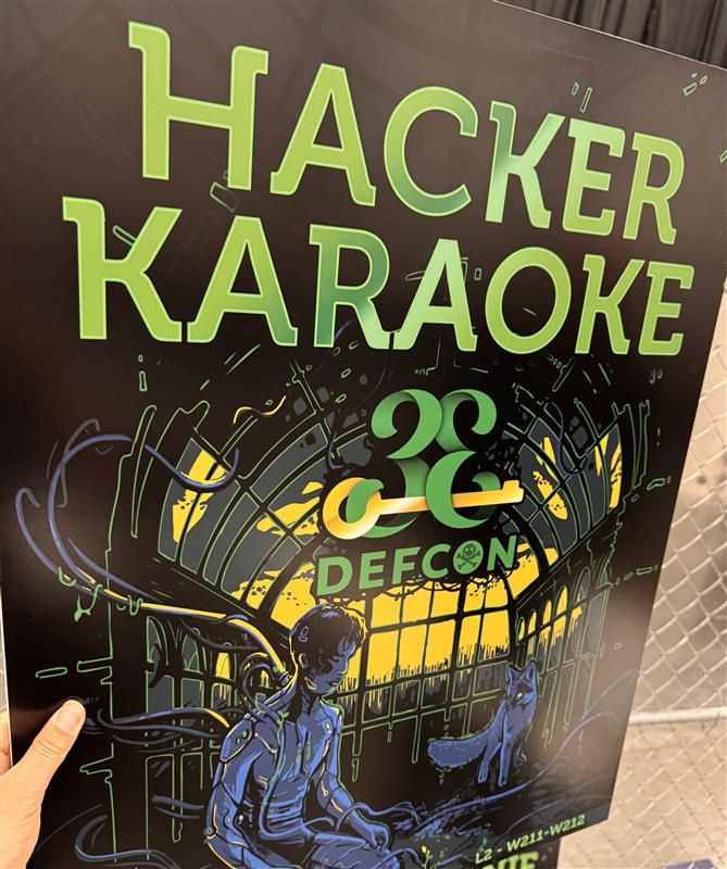 Hacker Karaoke DEF CON 33 sign (Text in green)
Black background with a male character sitting down at an interior bay window on the left and a fox sitting next to them on the right
Lower right hand corner has L2 - W211 - W212 (room location indicators)