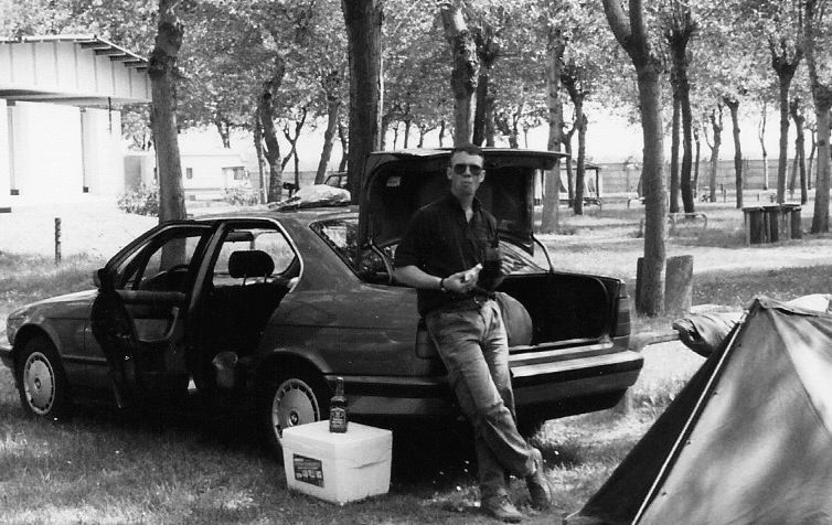 DHam on a 4 day pass. He's at a campground on the coast of northern Italy. He's causally leaning against the driver's side rear bumper of a BMW 5 series sedan, rented from the Budget Rent A Car at the Nűrnberg Airport in Germany. 

The trunk is open & he's holding a PB&J sandwich. Set up on the beach is a standard Army issue shelter-half tent.