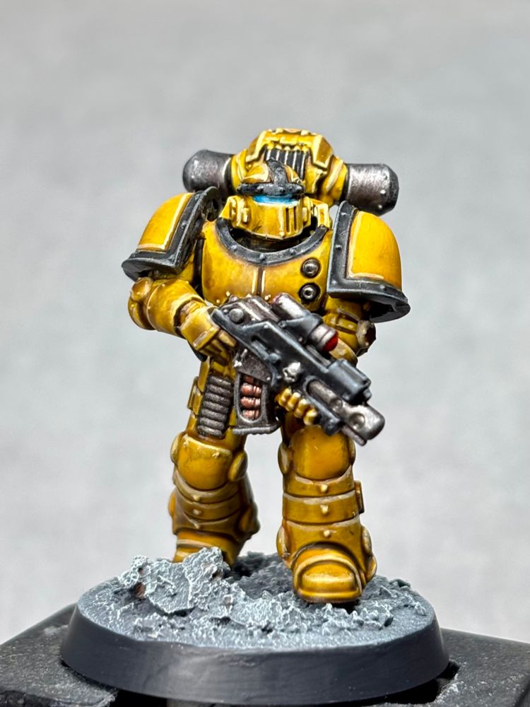 Space Marine in Mk2 armour. Armour is yellow with black trim and metallics are steel, on a grey rocky lunar style base.