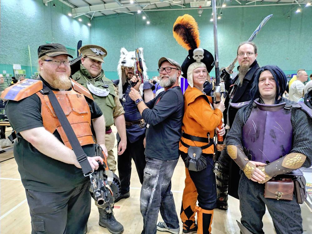 Photograph of the 601st Cosplay Group with author Dan Abnett at Broadside Wargames show in Medway on Saturday 14th June 2025. From left to right, we have:

Spc DM, 601st Mortressan Planetary Assault Grenadiers (Quartermaster & heavy weapons trooper)

Lt "Candy" Singleton, 45th Cadian Shock

Rune Priest "Icepack" Lyle

Dan Abnett, on temporary secondment to the Ordo hereticus (he's borrowing my pistol)

Empire Greatsword Ermintrude

Inquisitor Doyle, Ordo Hereticus

Orion Dahrk, Dark Elf Thrower in the Naggaroth Leagues (I forget what team he's in but they want to make it to the Blood Bowl this year)