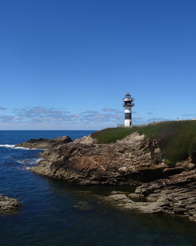 Faro sobre un acantilado con la desembocadura de la ría en primer plano
