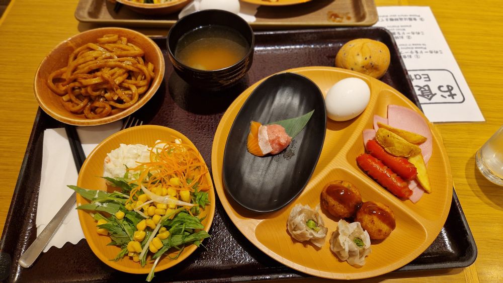 Bandeja con varios platillos de comida con sopa de miso, noodles, ensalada, sashimi, etc.