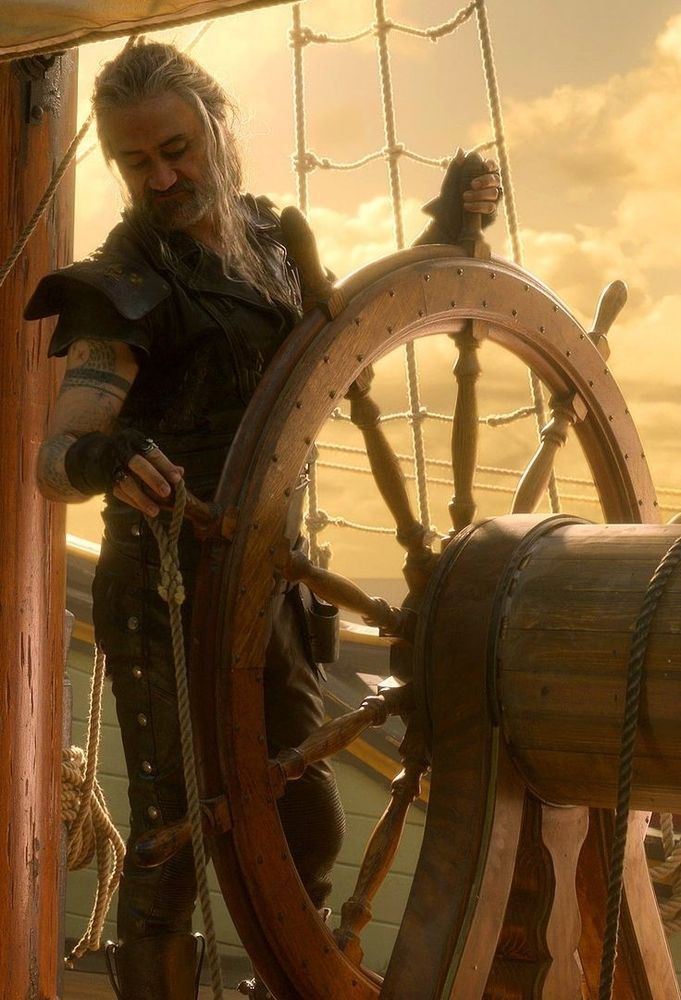 A close up frame from ofmd season 2 episode 2 of ed with his slutty bun and slutty waist behind the revenge's wheel