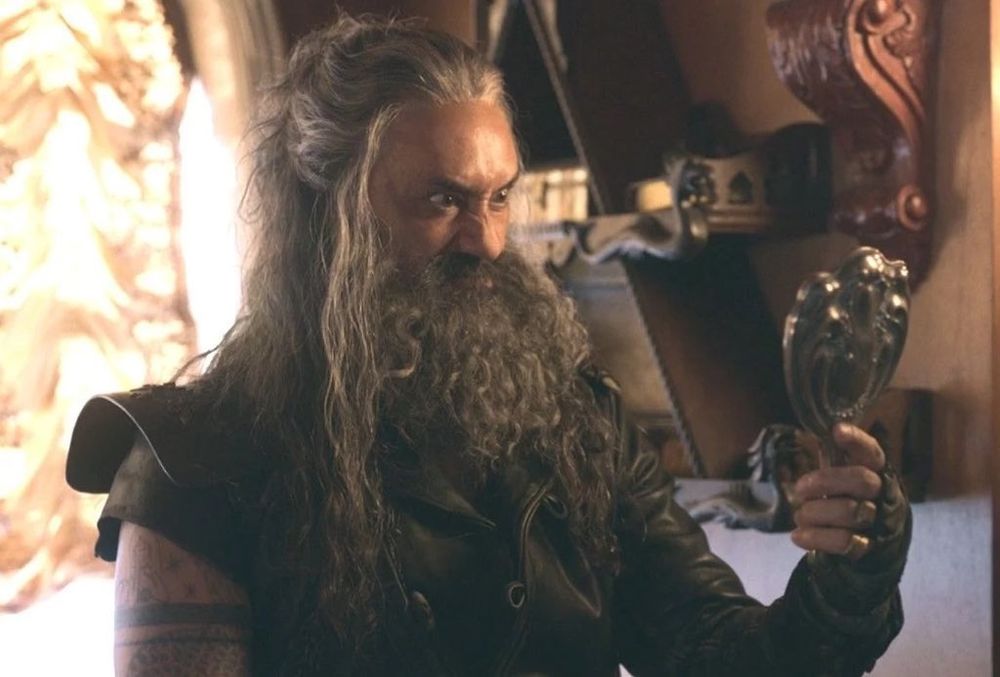 A picture from ofmd season 1 episode 4 of ed making an adorable face while looking in the mirror