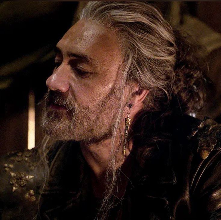 A screenshot from ofmd season 2 of ed's side profile with the slutty bun and earring