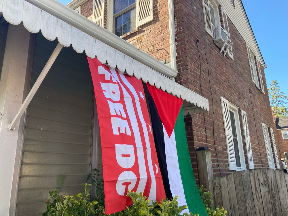 Free DC and Palestine flags hanging from an awning