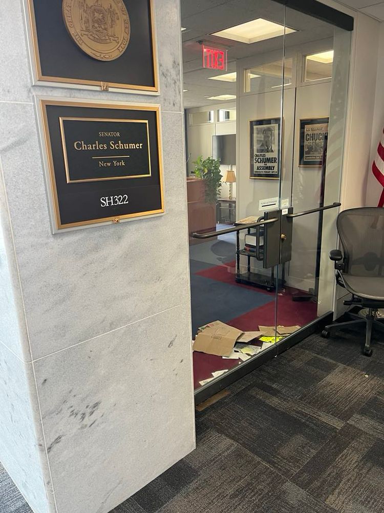 Schumers glass office door, closed, with letters and signs shoved underneath the cracks.